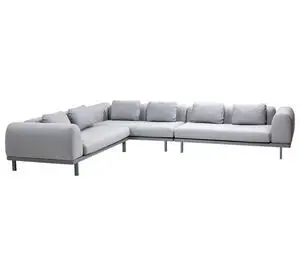 L-formet modulsofa i lys grå med ryghynder og korte ben. Enkel og lavprofil design.